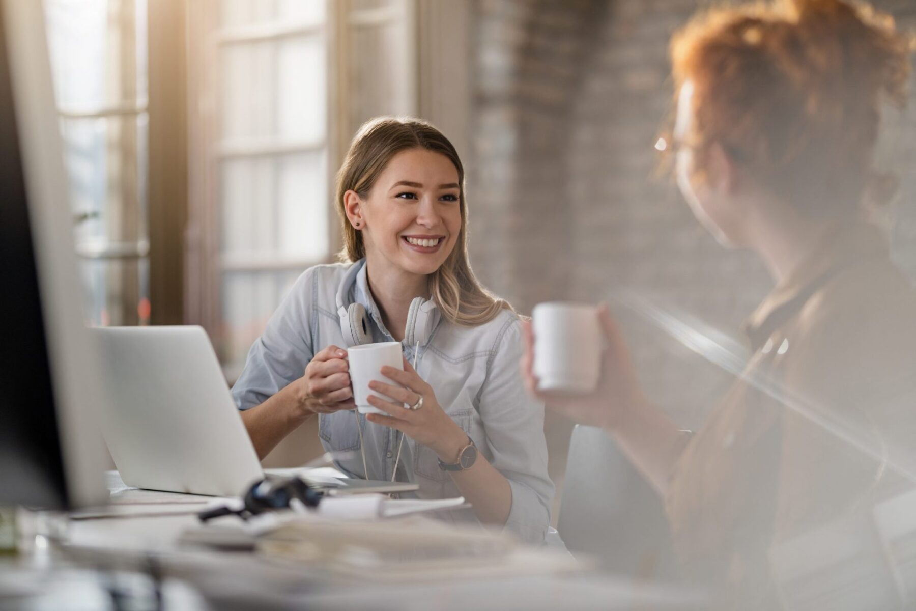 duas mulheres profissionais a falar, mostrando equilíbrio entre trabalho e vida pessoal